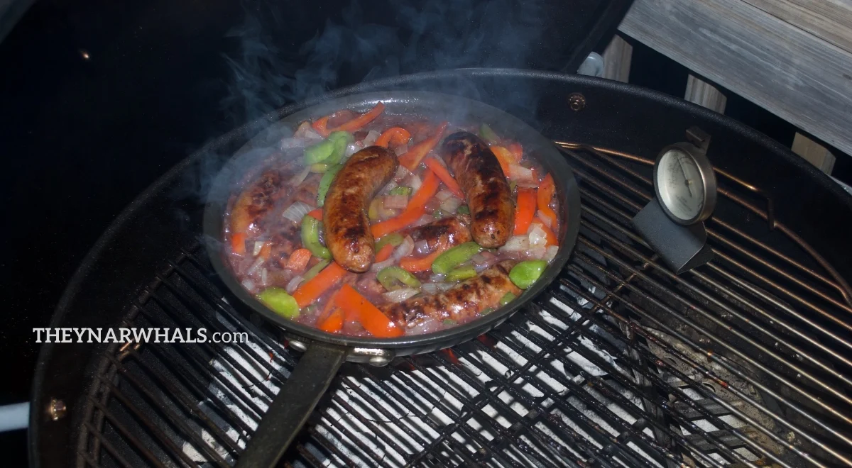 Italian sausages with peppers, onions and wine reduction on the grill.