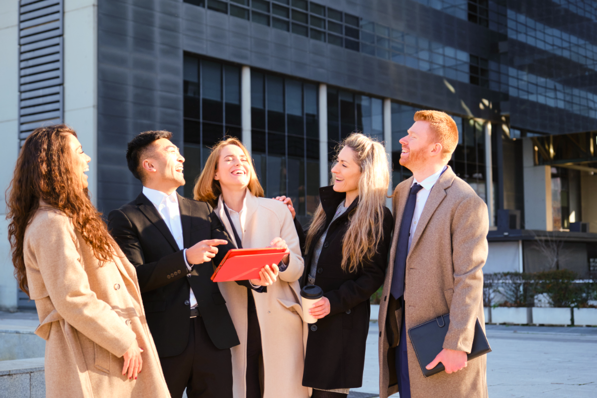 a photo of several young professionals meeting on the sidewalk in an urban environment